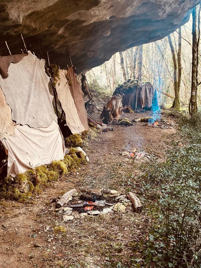 Primitif - décor cave préhistorique avec feux de camp et peaux